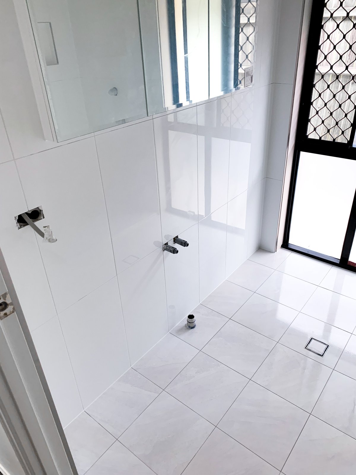 Shower with white subway wall tiles and patterned heritage floor tiles