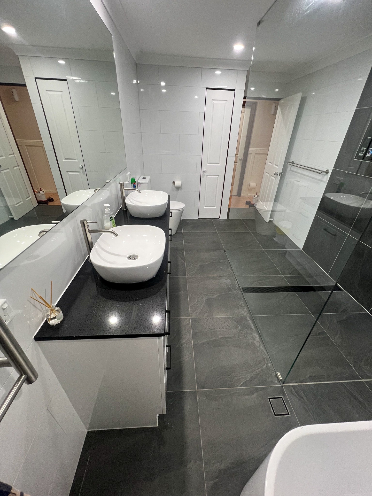 Double vanity with vessel basins against white wall tiling